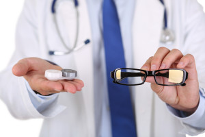 Male doctor hands giving pair of black glasses